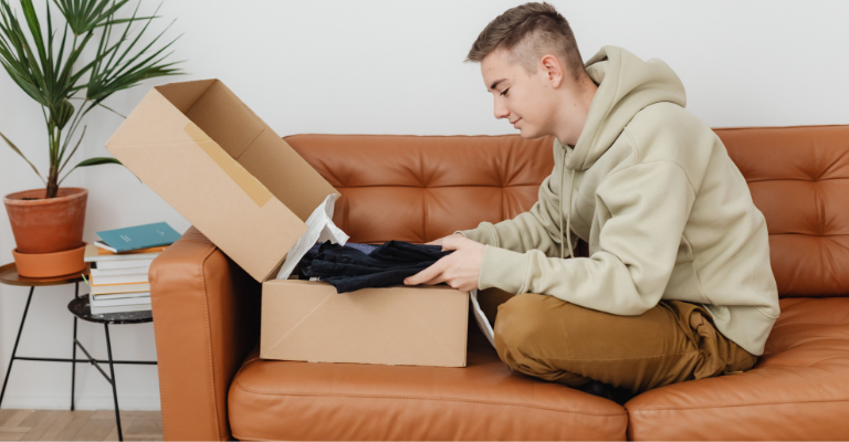 Ragazzi che inserisce in una scatola dei vestiti