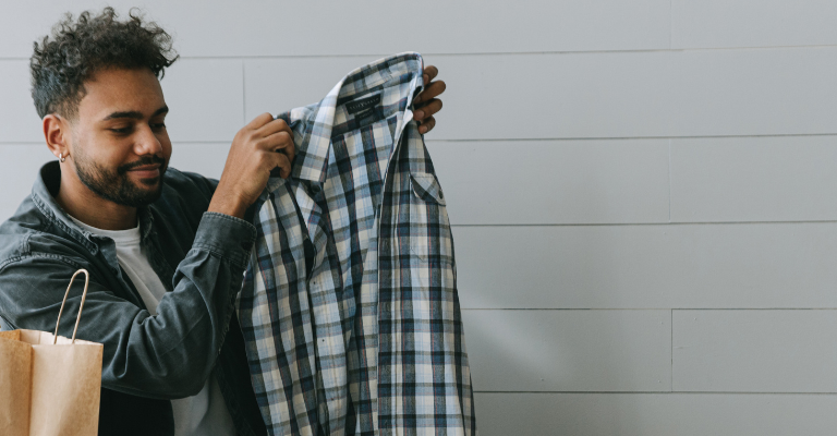 Ragazzo che sta mettendo una camicia dentro una scatola