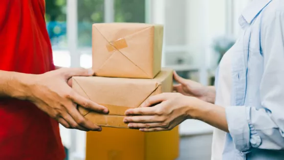 Persone che si passano un pacco di cartone