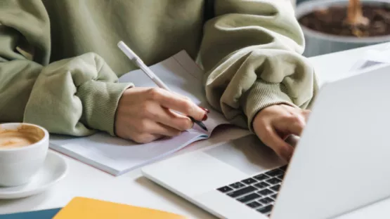 Persona al PC che prende appunti