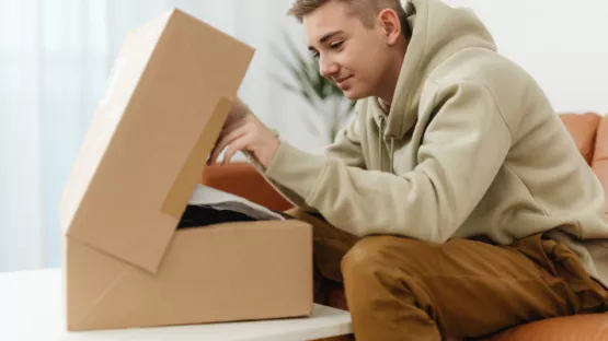 Ragazzo che sta preparando un pacco da spedire 