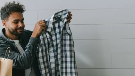 Ragazzo che sta mettendo una camicia dentro una scatola
