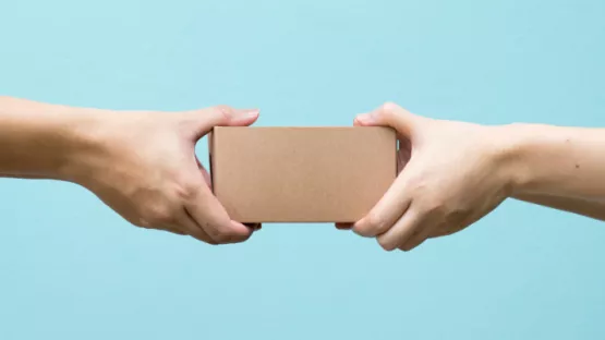 Due persone che si scambiano una scatolina