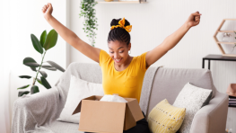 Ragazza con le braccia in alto felice di aver preparato un pacco