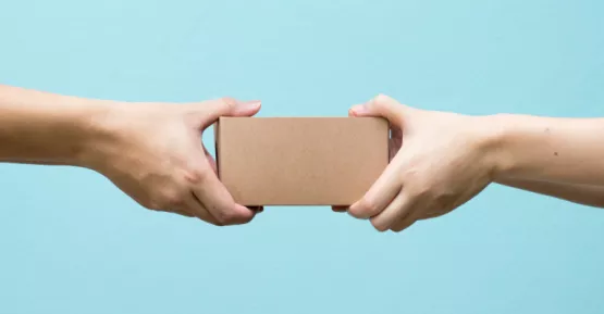 Due persone che si scambiano una scatolina